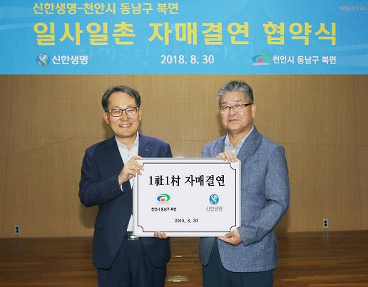 김무하 신한생명 경영지원그룹장(왼쪽)과 박재웅 천안시 동남구 북면장이 지난 30일 서울 중구에 위치한 신한생명 본점 대강당에서 1사1촌 자매결연 협약을 체결한 뒤 기념촬영을 하고 있다. 신한생명 제공
